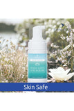 Scented Hand Foam Sanitiser bottle with White Lotus & Seagrass scent amidst wildflowers, labeled "Skin Safe."